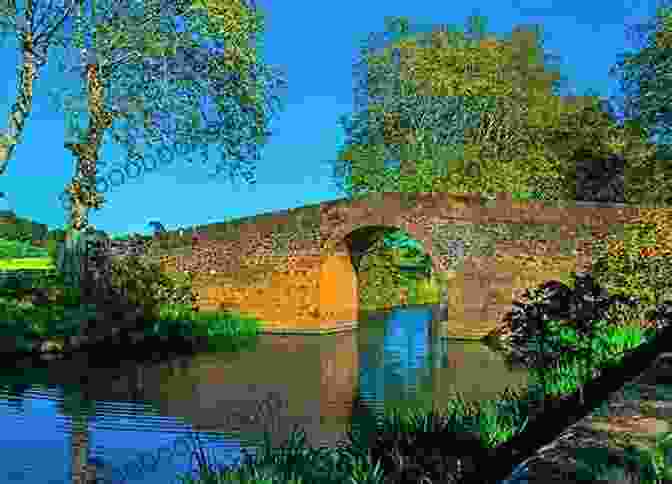 A Picturesque Stone Bridge Spans A Narrow Canal, Creating A Serene And Captivating Scene. Around Britain By Canal: 1 000 Miles Of Waterways